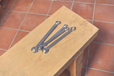Ahşap çalışma masasında İngiliz anahtarı seti.