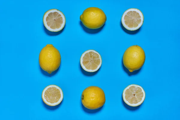 Whole and split lemons on a blue background. CITRUS CITRIC