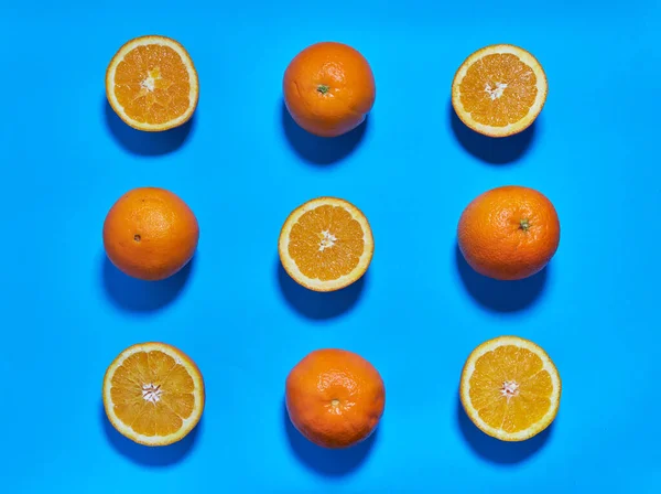 stock image Whole and split oranges on a blue background. CITRUS CITRIC