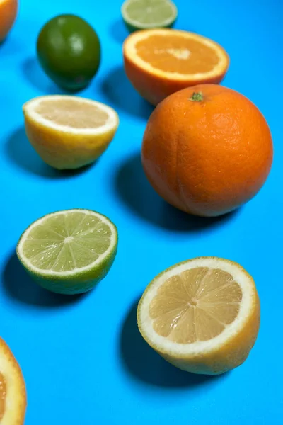 Portakallar, limonlar ve limonlar mavi arka planda. CITRUS CITRIC