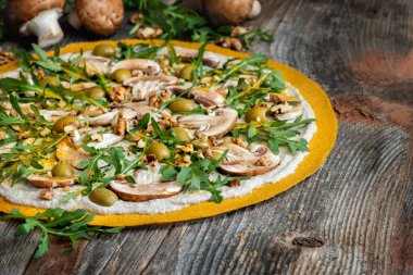 Mantarlı, cevizli, roka ve yeşil zeytinli lezzetli çiğ pizza..