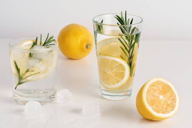 İki bardak limon dilimleri, biberiye ve buz..