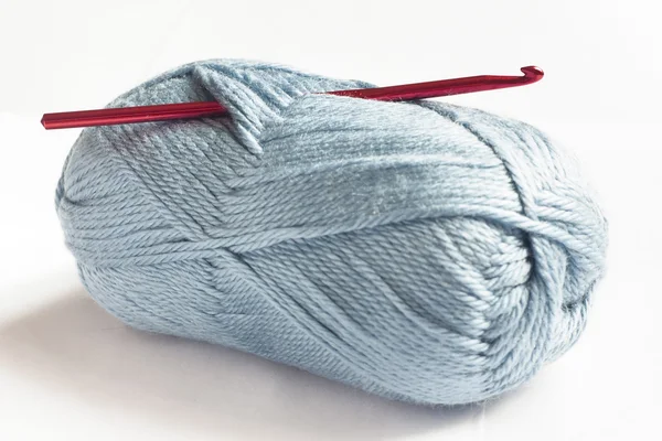 Lã azul e gancho de crochê vermelho — Fotografia de Stock