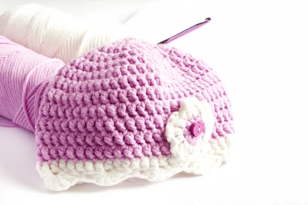 Yarn and pink baby hat — Stock Photo, Image