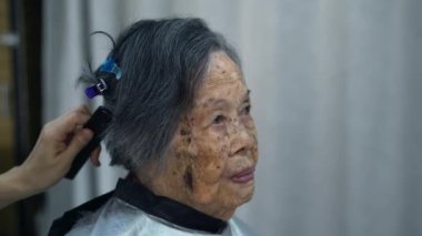 Evinde saçlarını bir kuaföre kestiren mutlu Asyalı kadın protraiti. Koronavirüs salgını sırasında evde kalıyor, karantina sırasında saç bakımı yapıyor.