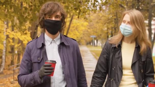 带着防护面具在公园里散步的情侣 — 图库视频影像