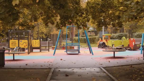 Parque infantil vacío en el otoño — Vídeo de stock