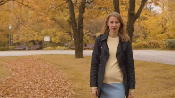 Ung kvinna promenader i parken — Stockvideo