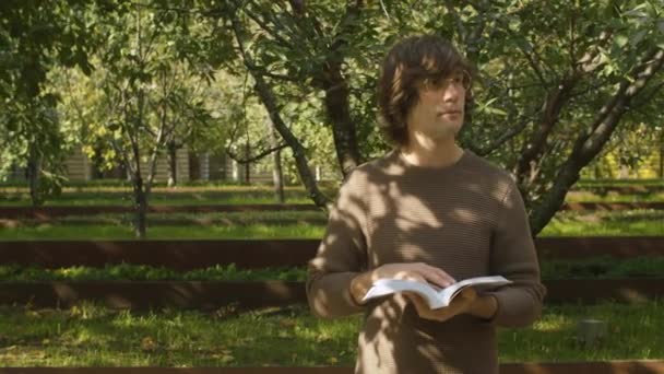 Hipster čte knihu v parku — Stock video