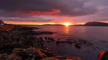 Faroe Adaları 'ndaki Torshavn' dan görünen Nolsoy adasının üzerinde güzel bir gün doğumu. Zaman aşımı klibi