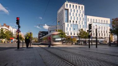 Tramvayların zaman klibi ve arka planda modern bir otelin önünden geçen insanlar. Le Havre, Fransa 'da görüldü.