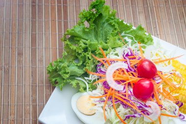 ahşap masa üzerinde beyaz tabak salata 