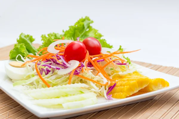 Salada na placa branca na mesa de madeira — Fotografia de Stock