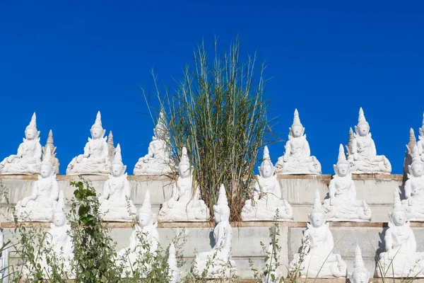 Rauwe witte buddha status op de muur — Stockfoto