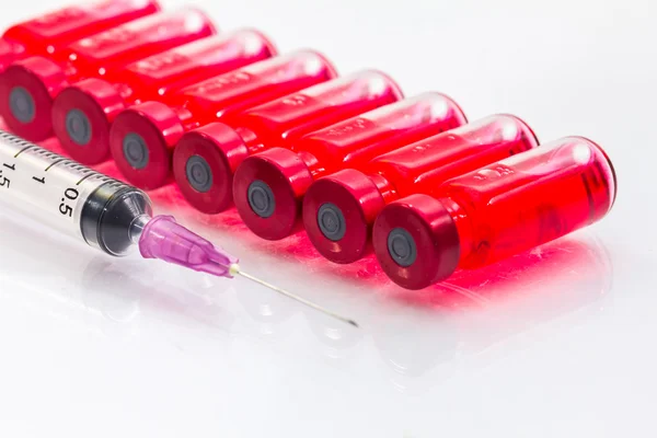 The vaccine and a hypodermic syringe — Stock Photo, Image