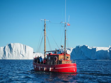 red boat in front of Icebergs  clipart