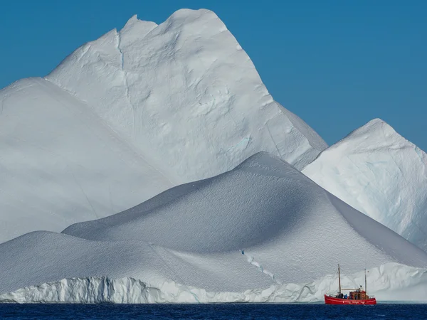 Czerwonej łodzi przed Icebergs — Zdjęcie stockowe