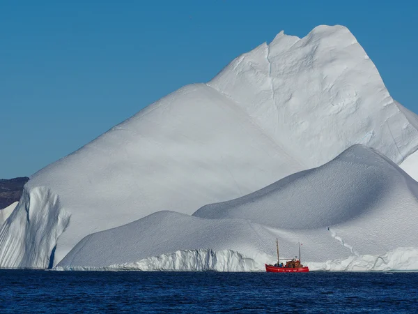 Czerwonej łodzi przed Icebergs — Zdjęcie stockowe