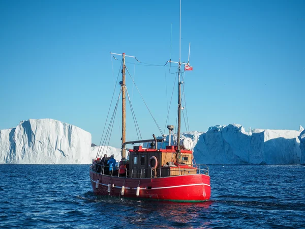 Czerwonej łodzi przed Icebergs — Zdjęcie stockowe