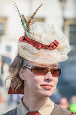 Muhteşem bir tüy şapka ve güneş gözlüğü güzel genç kadın