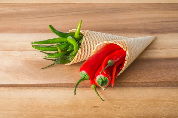 Red and green hot chili peppers in wafer cones — Stock Photo, Image