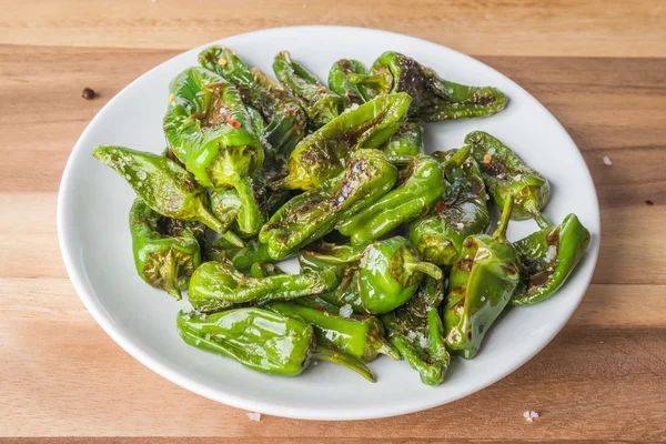 Rostad Padrón peppers på en tallrik — Stockfoto