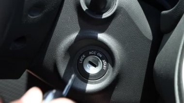 Adam kontak anahtarını yerleştirir ve arabayı çalıştırır..