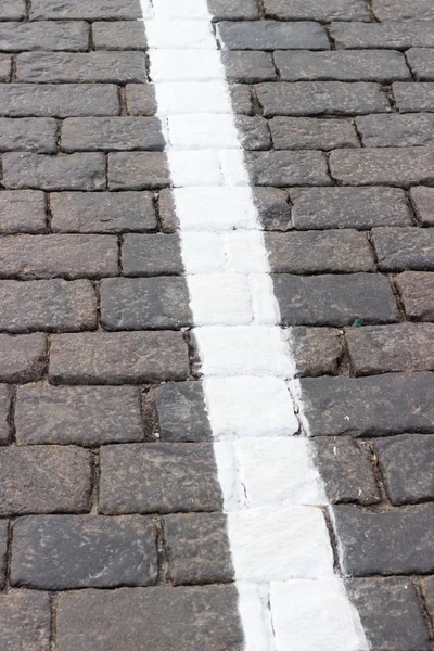 La línea blanca en el camino que retrocede la piedra — Foto de Stock
