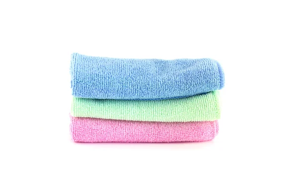 Las toallas rosadas, azules y verdes ruedan horizontalmente sobre un fondo blanco Fotos de stock libres de derechos