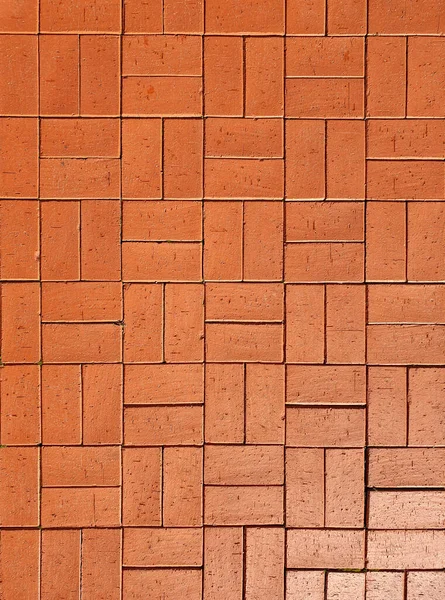 Kırmızı kaldırım taşından yola bak. Kırmızı granit desenli bir bina. Soyut arkaplan.