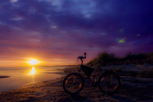 Bicicleta estacionária ao pôr do sol céu lindamente . — Fotografia de Stock