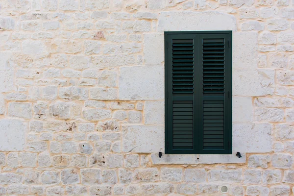 Ancient stone wall with door and window.