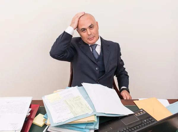 business man at desk, deep in thought.