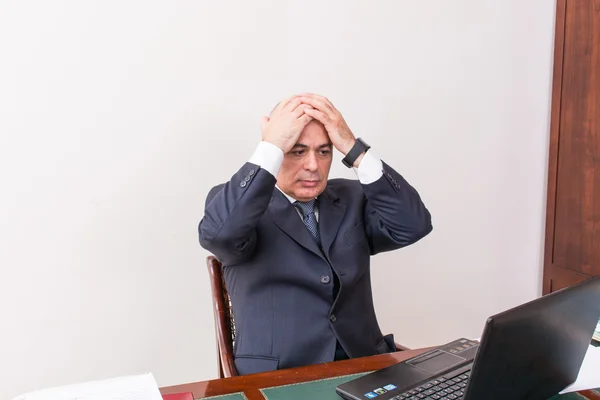 business man at desk, deep in thought.