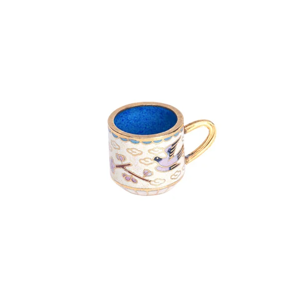 Tiny ceramic cup with a painted patterns in gold on a white back — Stock Photo, Image