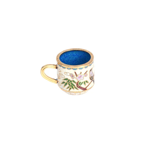 Tiny ceramic cup with a painted patterns in gold on a white back — Stock Photo, Image
