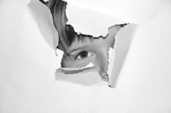 Teenie-Mädchen schauen aus Loch in weißem Papier — Stockfoto