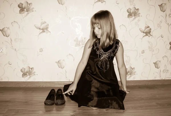 Teenie-Mädchen sitzt auf dem Boden in der Nähe von schwarzen Schuhen — Stockfoto