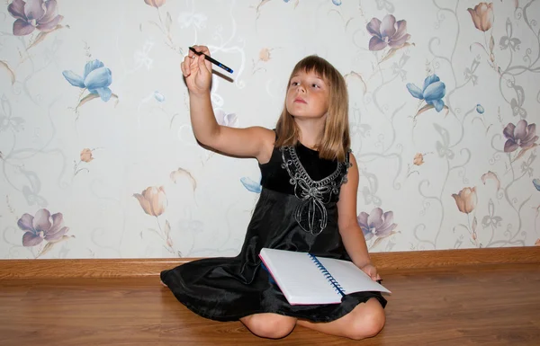 Gilr sits on the floor with notebook in hands — Stock Photo, Image