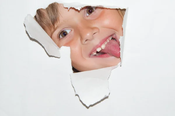 Adolescente chica mirada desde agujero en blanco papel Imagen de stock