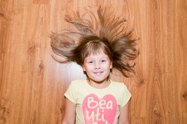 Girl on the floor smiles — Stock Photo, Image