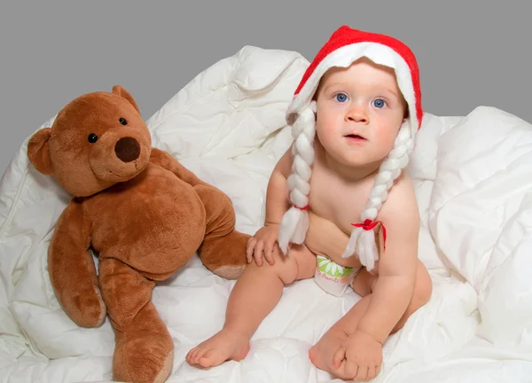 Menino de chapéu de Natal com ursinho de peluche — Fotografia de Stock