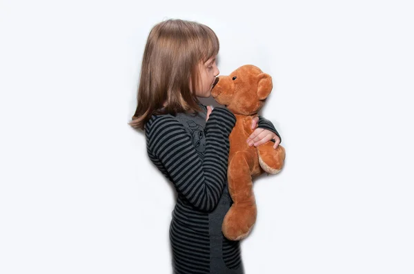 Девочка целует игрушечного медведя — стоковое фото