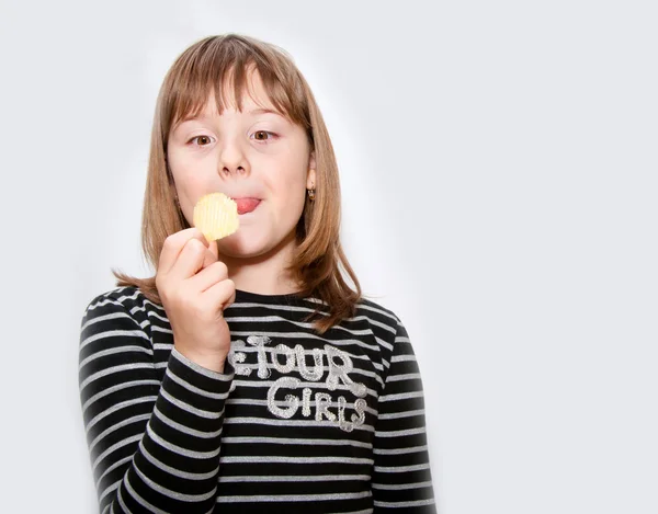 Teen girl eats chips — Stock Photo, Image