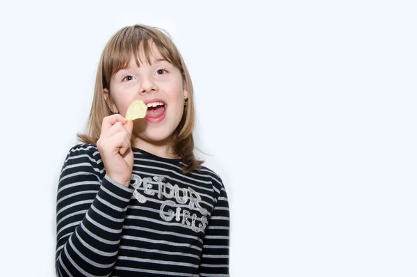 Teen girl eats chips — Stock Photo, Image