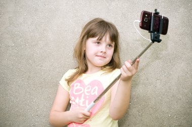 Kız selfie monopod ile elinde yapar.