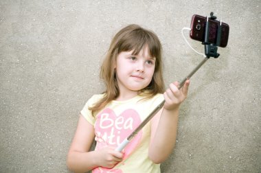 Kız selfie monopod ile elinde yapar.