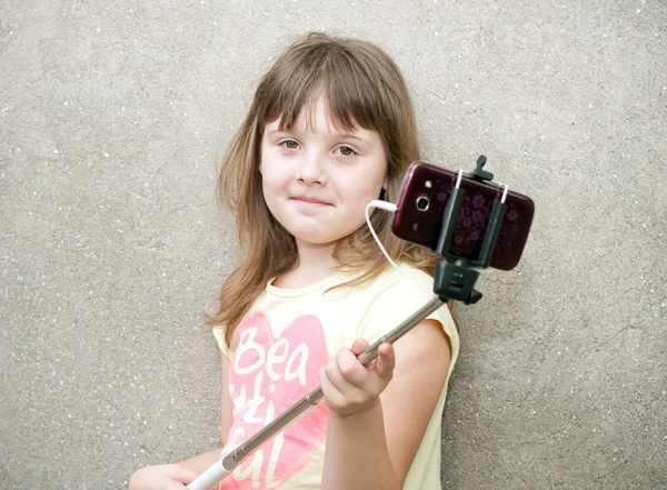Girl makes selfie with monopod in hands — Stock Photo, Image