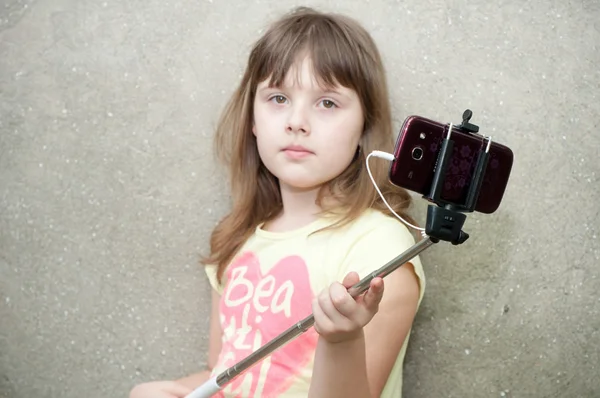 Flickan gör selfie med enbensstativ i händer — Stockfoto