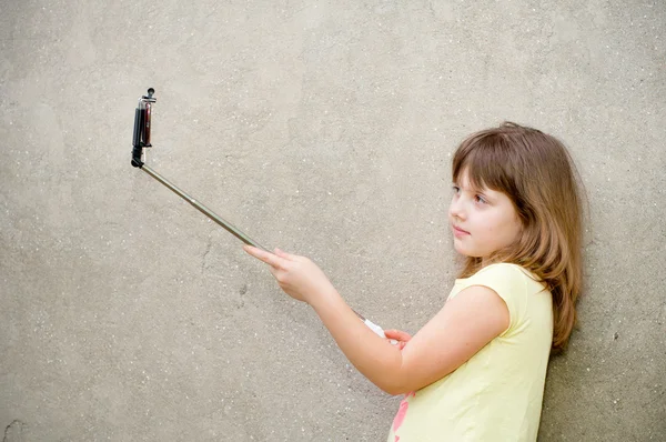 Flickan gör selfie med enbensstativ i händer — Stockfoto